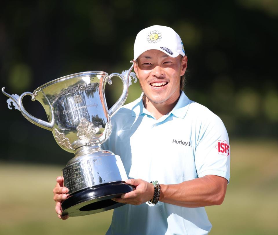 優勝カップを手に笑顔を見せる藤本佳則（撮影・坂部計介）
