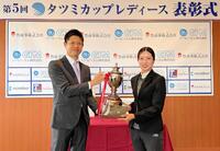 　（株）タツミコーポレーション・李煥辰代表取締役社長（左）から優勝トロフィーを受け取る安本美咲