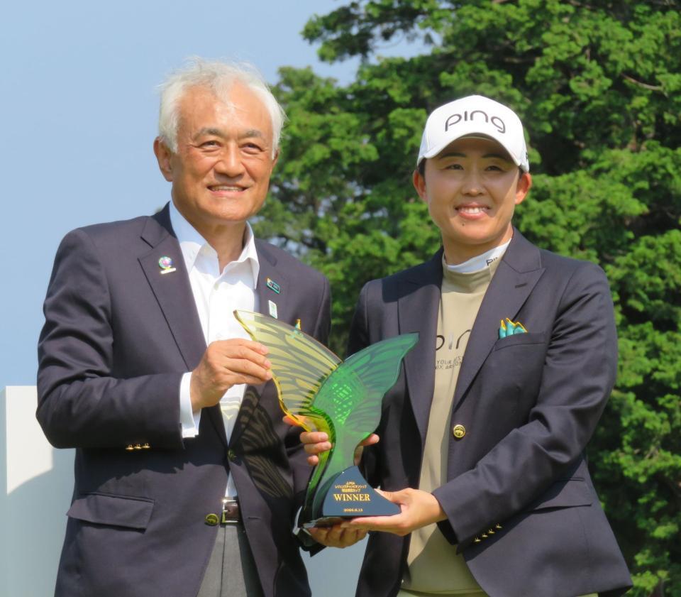 明治安田・根岸秋男会長（左）から特別協賛杯を贈られ笑顔の前田陽子