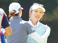 ホールアウトし、同組の金沢志奈とあいさつを交わす金田久美子