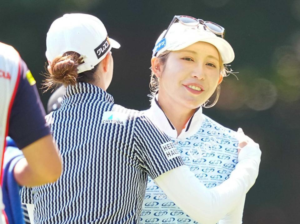 ホールアウトし、同組の金沢志奈とあいさつを交わす金田久美子