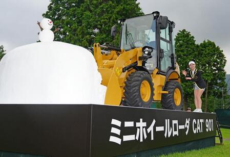 優勝副賞の重機の前で笑顔の吉田鈴