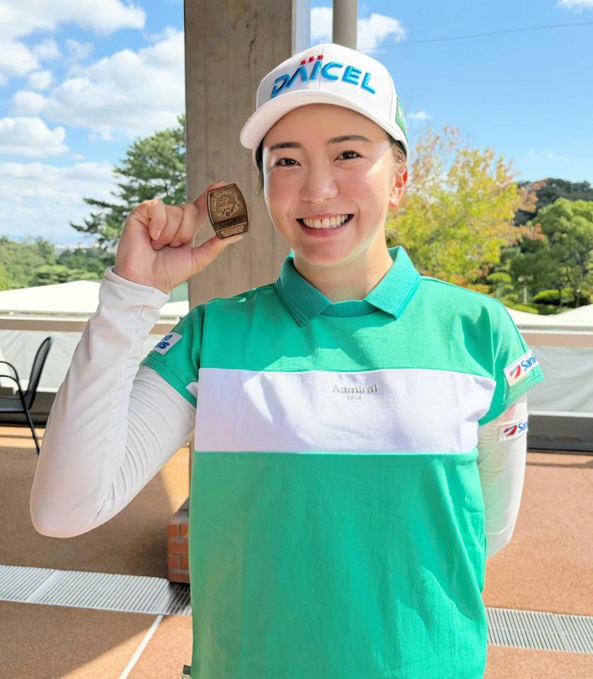 　歴代優勝者に与えられるゴールドの出場バッジを手に笑顔の堀琴音
