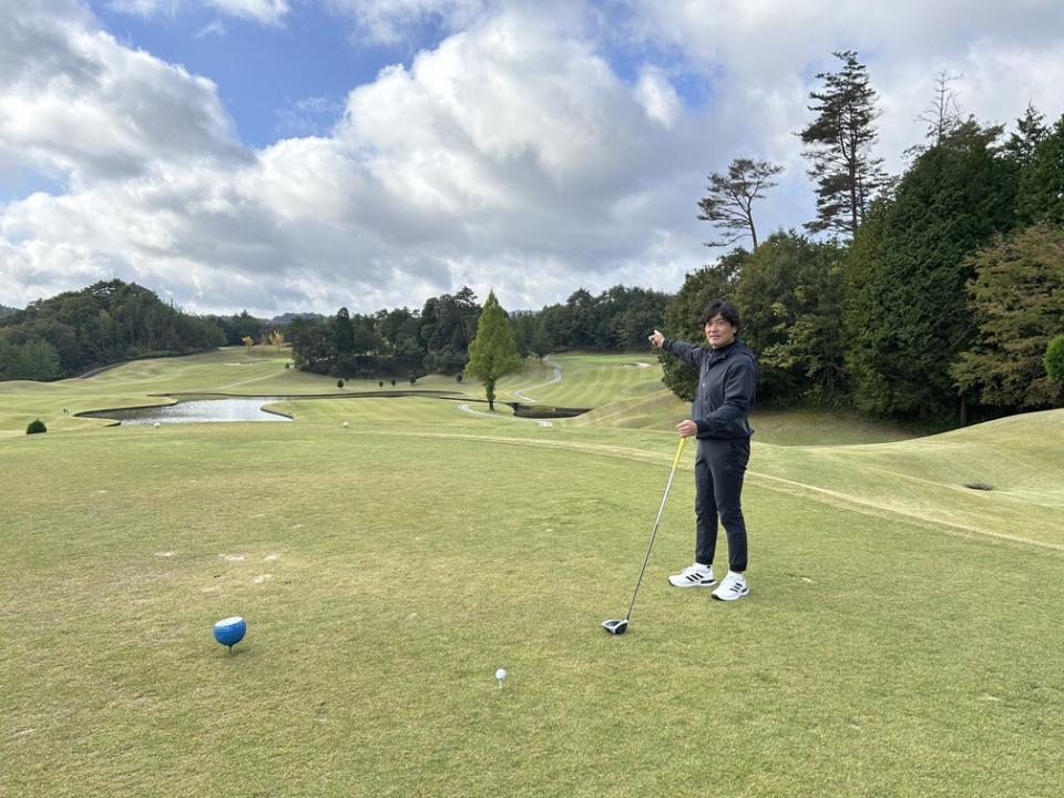 池がフェアウエーを横切る最難関８番パー４のティーイングエリアに立つ大畑さん