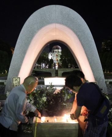 　６７年目の「原爆の日」を迎え、原爆ドーム（奥）を望む平和記念公園で祈りを捧げる人たち（撮影・市尻達拡）