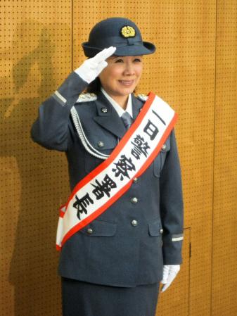 礼服に身を包み、笑顔で敬礼する森昌子