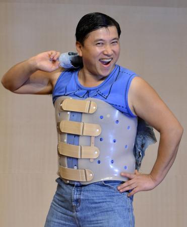 　コルセットを装着し復帰会見で元気な姿を見せるスギちゃん（切り込み写真）背中には「ワイルドだろ」の文字＝東京・なかの芸能小劇場（撮影・会津智海）