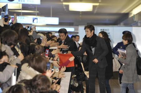 　出迎えたファンにサービスするイ・ビョンホン＝羽田空港