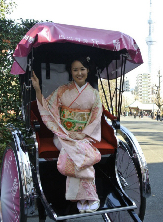 　東京スカイツリーをバックに人力車に乗る田川寿美＝東京・浅草寺