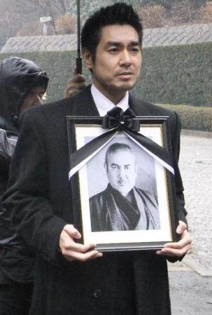 父・本郷功次郎さんの遺影を抱きながら思い出を語る本郷壮二郎＝横浜市