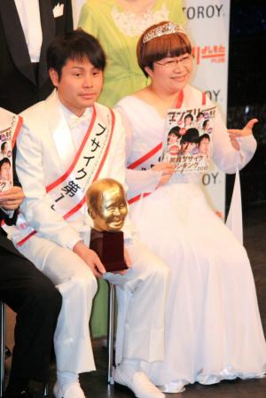 トロフィーを手にする井上裕介（左）と近藤春菜＝東京・新宿