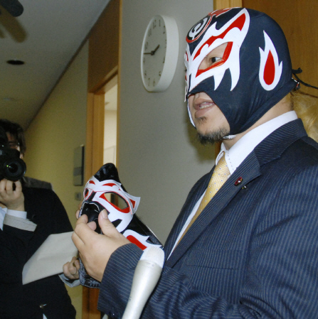 　試作したマスクを手に、記者の質問に答える覆面レスラーのスカルリーパー・エイジ＝大分市議会