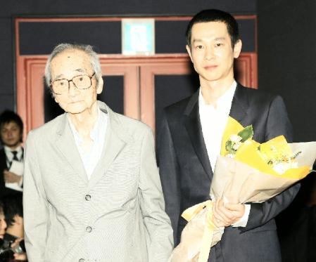 木下惠介監督の実弟・木下忠司氏（左）から花束を受け取った加瀬亮＝東京都千代田区の丸の内ピカデリー