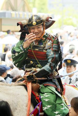 　甲冑姿で照れ笑いを浮かべながら、武者行列に参加するデイリースポーツ評論家の浜中治氏＝神戸市（撮影・峰大二郎）