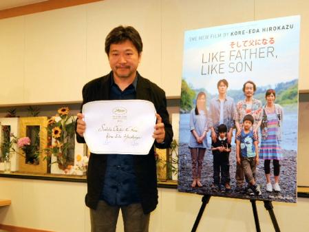 賞状を手に笑顔をみせる是枝裕和監督＝千葉・成田空港