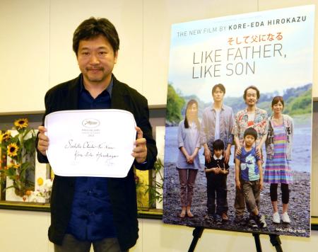 　賞状を手に笑顔を見せる是枝裕和監督＝千葉・成田空港　（顔写真は）スピルバーグ氏（ＡＰ＝共同）