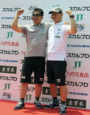 全盲のセーラー岩本光弘氏と出発前にガッツポーズを披露する辛坊治郎氏（右）＝大阪市此花区の大阪北港ヨットハーバー