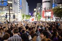 　日の丸を掲げ喜ぶサッカー日本代表サポーターら＝東京都渋谷区