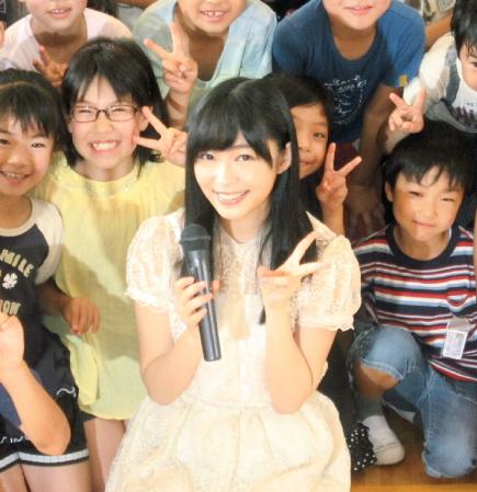 子どもたちに囲まれ笑顔でＶサインを見せる指原莉乃＝大分市内