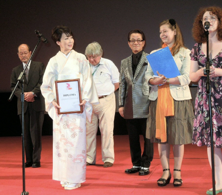 「特別作品賞」の賞状を受け取り、笑顔の伊藤蘭（左から２人目）と水谷豊（同４人目）＝モスクワ市のオクトーバー劇場