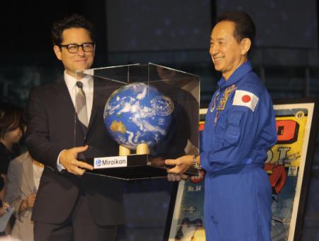 　Ｊ．Ｊ．エイブラムス監督（左）に地球儀を手渡す毛利衛氏＝東京・台場