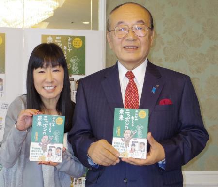 　自著を手に笑顔を見せる中野寛成氏（右）とハイヒール・リンゴ＝大阪市内