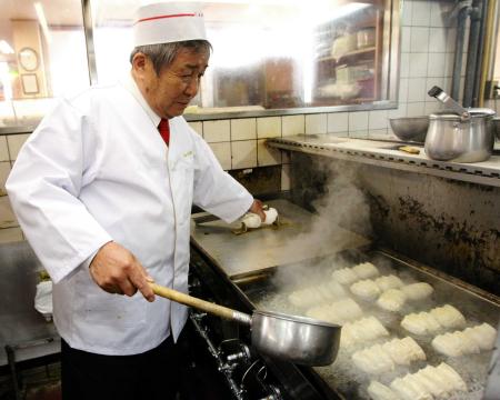 自ら厨房に立ち餃子を焼く王将フードサービス・大東隆行代表取締役社長＝０９年７月１７日