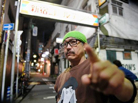 　飲み屋街の明かりを背にポーズをとるコダカラー・清志＝東京・新宿ゴールデ　ン街（撮影・吉澤敬太）