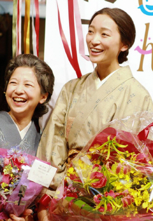 「ごちそうさん」の撮影を終え、花束を受け取り笑顔の杏、左は宮崎美子＝ＮＨＫ大阪放送局
