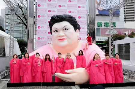 　巨大マツコオブジェの前でポーズをとる北条ふとし（右から４番目）とイメチェンマツコたち＝ＪＲ新宿駅東口前広場