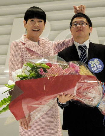 発毛日本一に輝いた鈴岡翔太さん（右）の髪の毛を確かめる和田アキ子＝東京・有楽町
