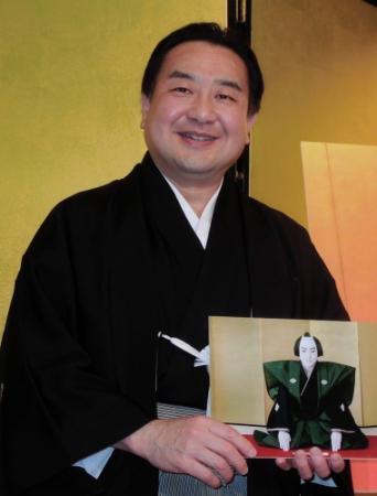 「イ菱」の紋が入った裃を着ての撮影を喜んだ中村翫雀。手に持っているのは父・坂田藤十郎が鴈治郎を襲名したときの写真
