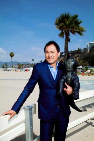 サンタモニカのビーチでゴジラを抱いてポーズを取る渡辺謙
