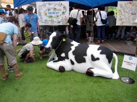 　六本木牧場に設置された乳牛のフィギュアに見入る親子連れ＝東京・六本木ヒルズ
