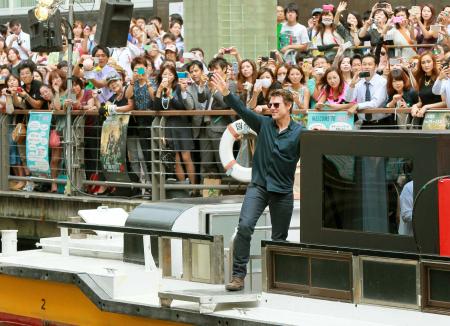 　船上から集まったファンの声援に応えるトム・クルーズ＝大阪・ミナミ　