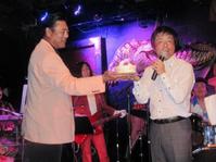 サプライズ登場した陸奥親方（左）からバースデーケーキを贈られる長江健次＝東京・原宿のクロコダイル