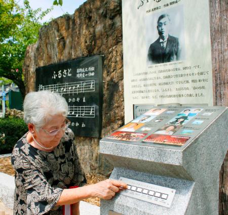 　唱歌「故郷」の音楽碑の音響装置が一新され、操作する作曲者岡野貞一の長男の妻、岡野玉重さん＝鳥取市の久松公園