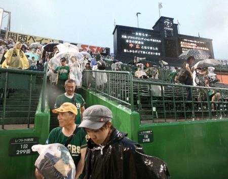 　雨で試合が中止になり残念そうに引き揚げる阪神ファン＝８月３日、甲子園