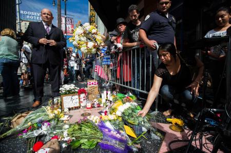 　１２日、米ハリウッドの観光名所「ウオーク・オブ・フェーム」で、ロビン・ウィリアムズさんの名前が刻まれた星形に花を供える人々（ロイター＝共同）