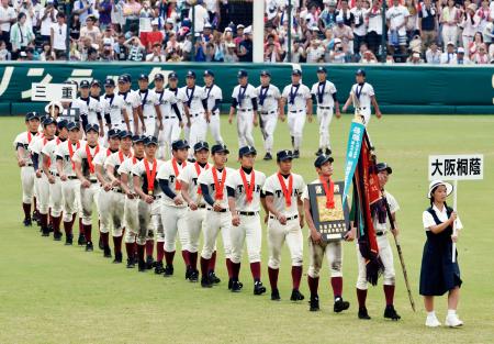 　優勝旗を先頭に場内一周する大阪桐蔭の選手。奥は準優勝の三重の選手