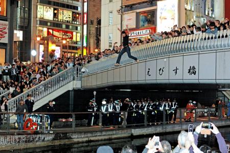 　阪神の日本シリーズ進出が決まり、えびす橋から次々と道頓堀川へ飛び込むファン＝大阪市中央区