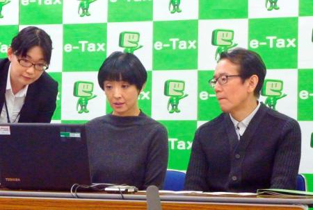 　ｅ－Ｔａｘを体験する（右から）映画監督の周防正行さんと女優の草刈民代さん夫妻＝１１日午前、東京都新宿区