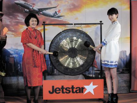 　大阪ー香港線就航セレモニーでドラを鳴らす桐谷美玲（右）とジェットスタージャパンの鈴木みゆき社長＝東京・恵比寿
