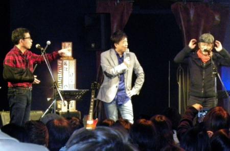リーゼントのカツラでワルオに扮した西山浩司（右）と長江健次（中）、山口良一（左）＝神戸チキンジョージ