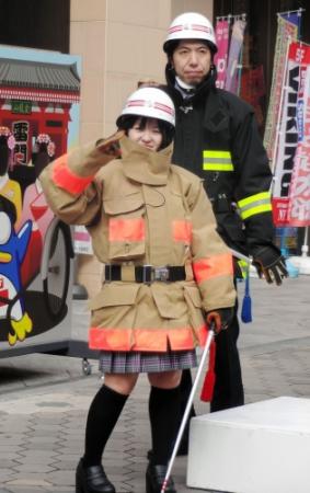 消防服で敬礼するさくらまや。後ろはねづっち＝東京・浅草