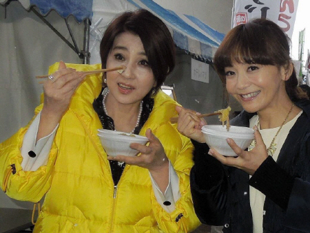 福島県の食材で作った鍋料理を堪能する秋吉久美子（左）と華原朋美＝福島県郡山市のビッグパレットふくしま