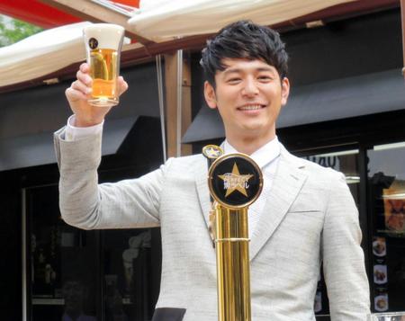 　２度目のサーブで成功し笑顔を見せる妻夫木聡＝東京・大手町のサンケイビル