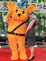 ピーポくんと敬礼する吉倉あおい＝都内