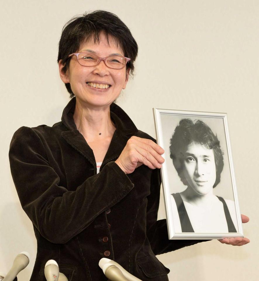 　２０歳の頃の萩原流行さんの写真を持って会見に臨んだ妻・まゆ美さん＝東京都内