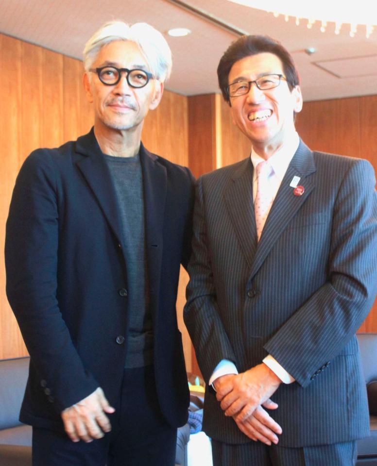 　札幌市の秋元克広市長（右）を表敬訪問した坂本龍一＝札幌市役所